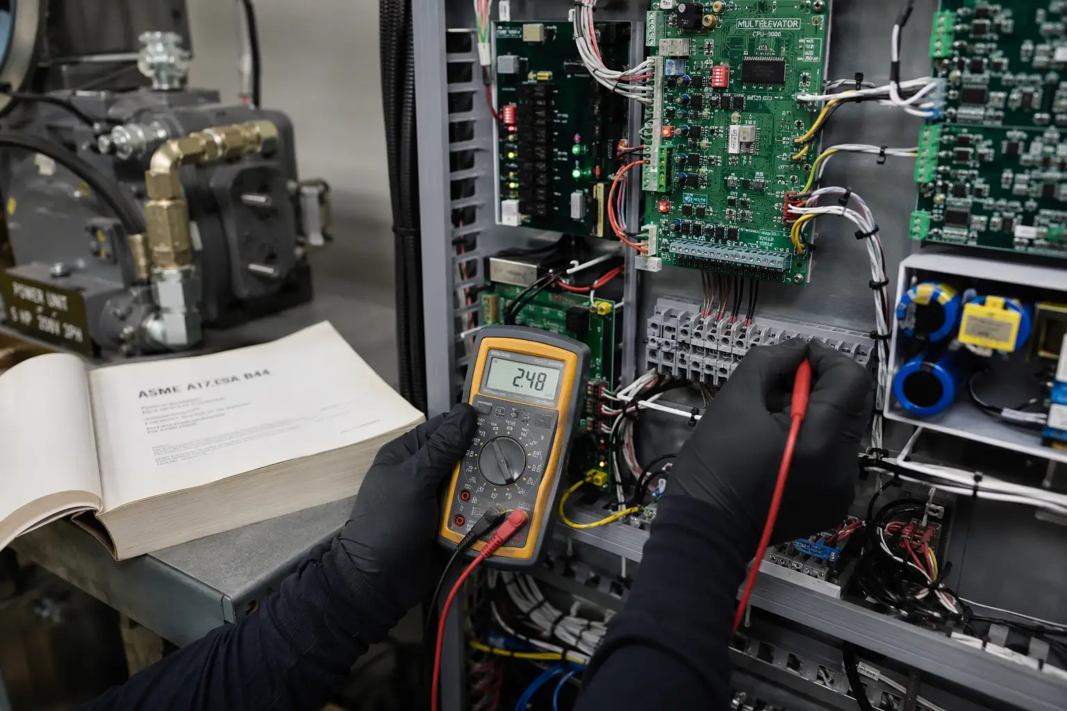 Elevator Machine Room Preventive Maintenance Detail Elevator technician testing machine room controller terminals during a preventive maintenance visit, covering the 40-to-60 inspection points required by ASME A17.1 Rule 8.6.
