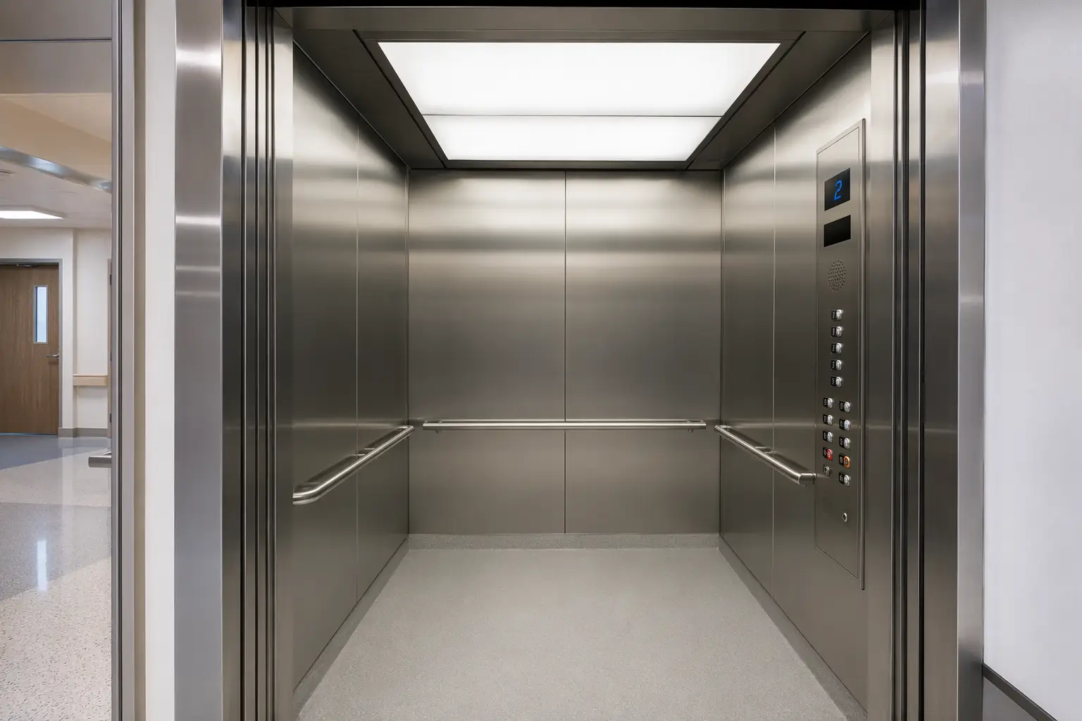 Modernized hospital elevator cab interior with ADA-compliant control panel, stainless-steel walls, and LED lighting — key cab upgrade components in a healthcare elevator modernization cost breakdown.
