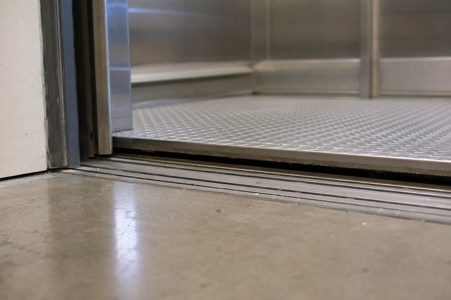 Elevator cab floor mis-leveled above landing threshold in a California commercial building, a key repair warning sign requiring immediate service