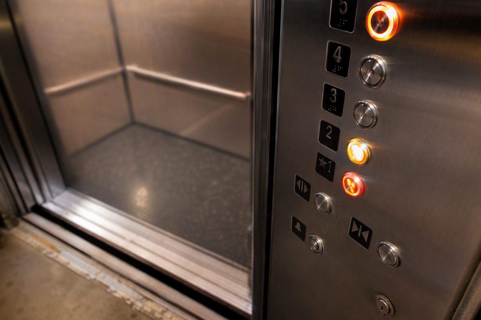 Flickering and unresponsive elevator call buttons on a car operating panel in a Long Beach residential building, a common sign of a failing elevator control system.