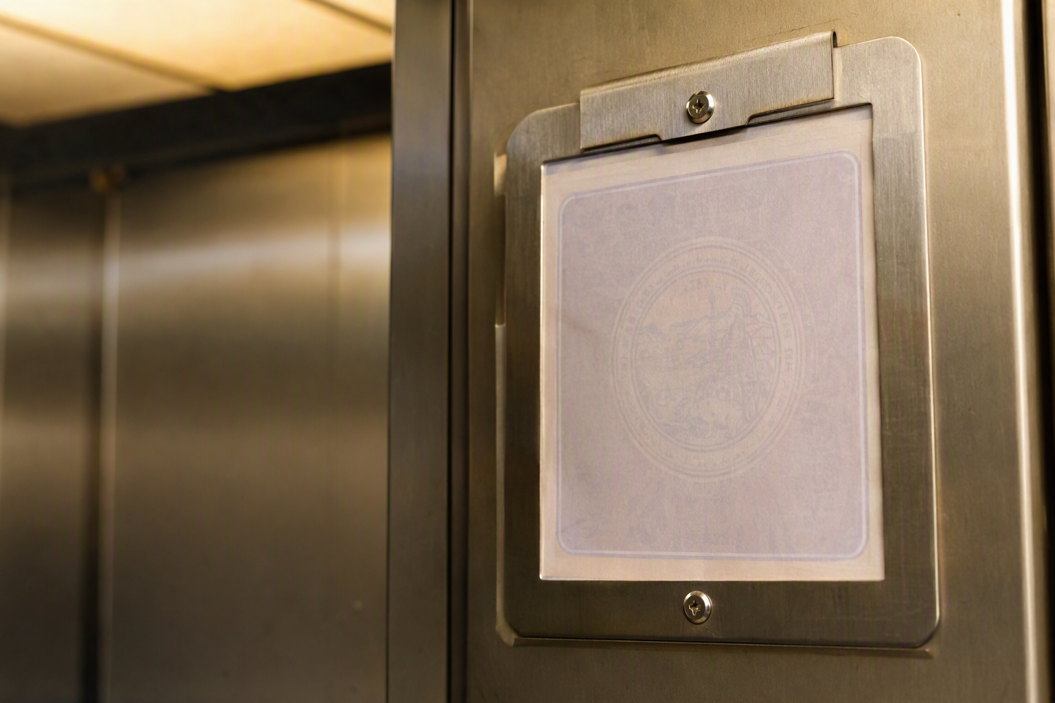 Cal/OSHA elevator operating permit posted inside a commercial elevator cab in California, required for healthcare tenant lease renewal compliance